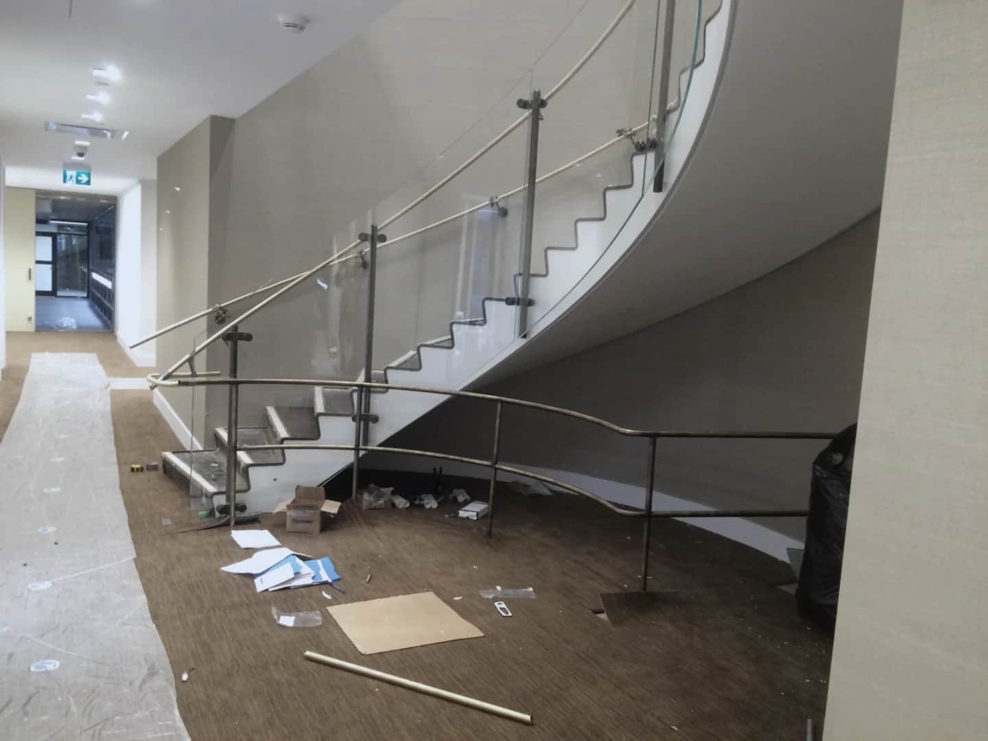 Bank of Canada, Ottawa: Curved stair with glass guardrail panels and handrails during installation, packing material on the floor