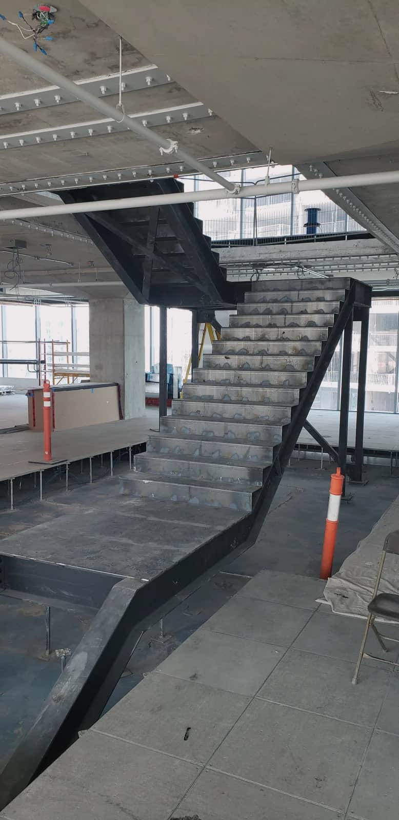 Steel stair with bare treads on a construction site, before finishes