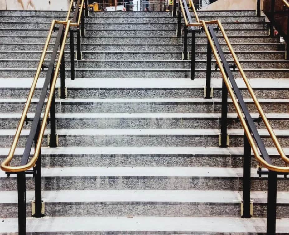 Union Station, Toronto: Stone steps with black posts and bronze handrails, seen from the foot of the stair