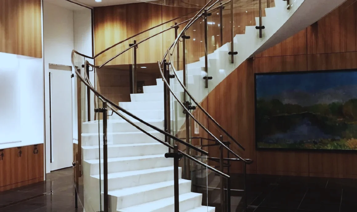 Bank of Canada, Ottawa: Curved staircase with glass guardrails in a wood-panelled lobby