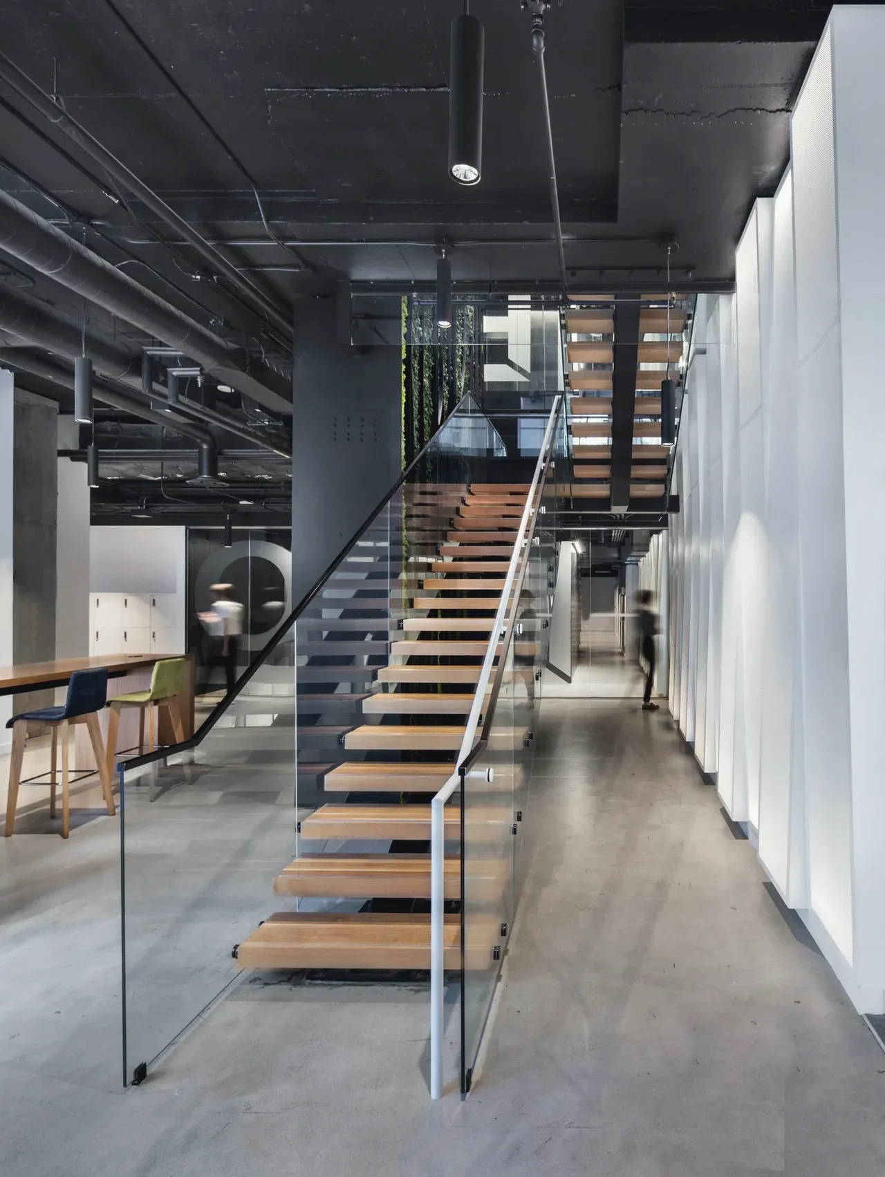 Living-wall stair, Toronto: Floating stair with wood treads and a full-height glass guardrail in an open office