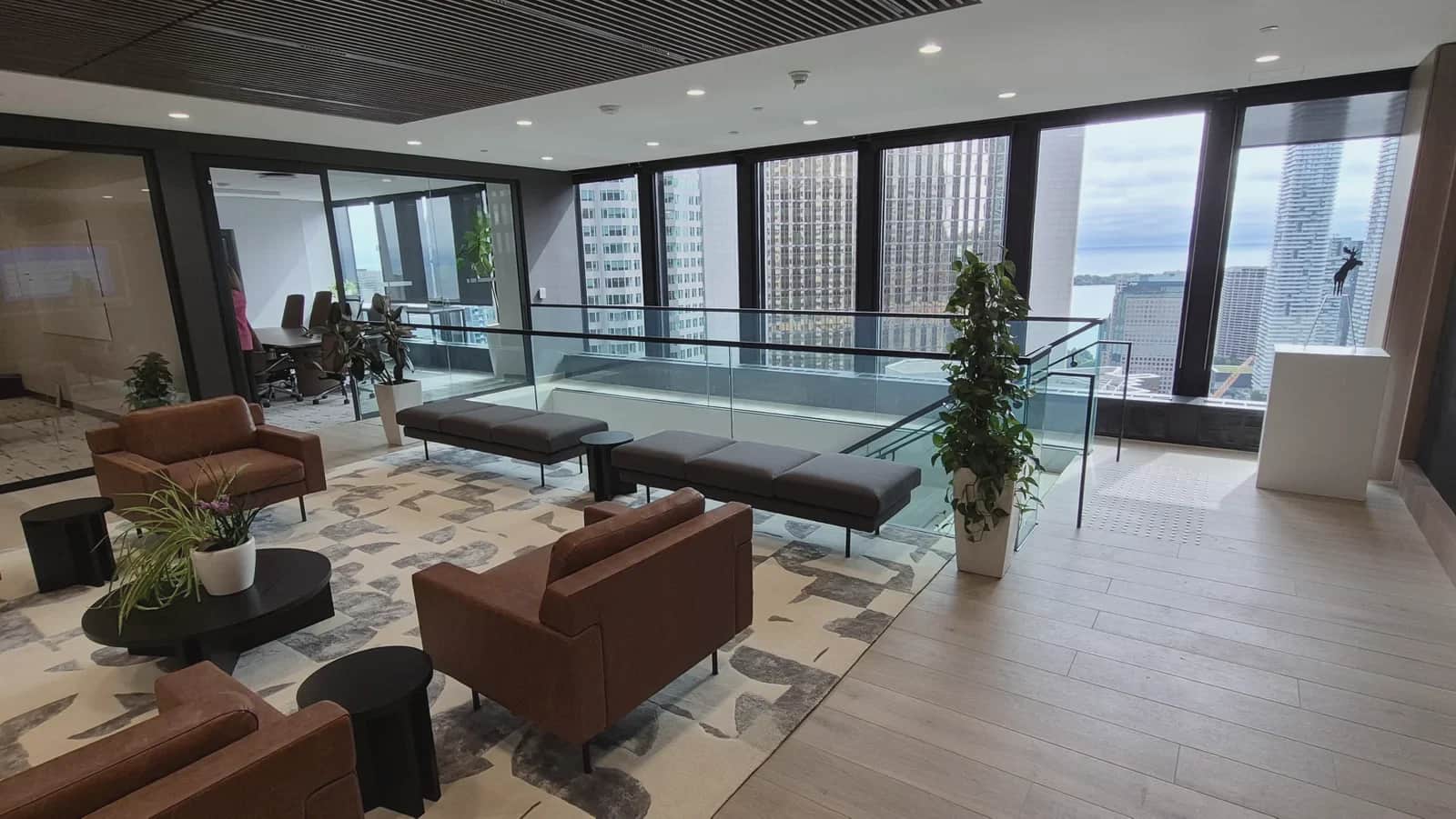 Office staircase, Toronto: Office lounge with the glass-guarded stair opening running along the windows